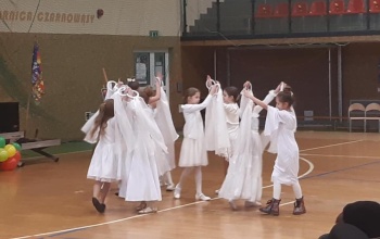 Powiększ obraz: dziewczynki ubrane na biało tańczą w kole